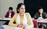 A student looking thoughtful while doing classwork