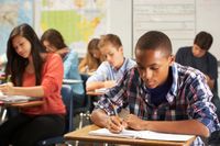 High school students writing in a social studies classroom