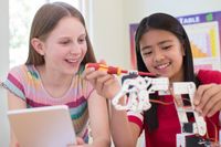 Two Female Pupils In Science Lesson Studying Robotics
