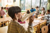 A student about to throw a paper airplane in class