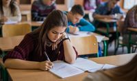 A high school student writes in a notebook in class