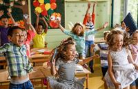 Elementary students jumping and playing in a classroom