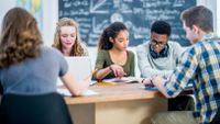 Diverse high school students studying together in class