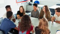 Students gathered around a table debating math