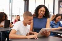 A teacher helps a teenage student