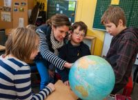 Teacher and students looking at a globe