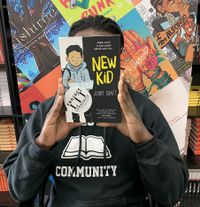 A student holds up a book from the school library