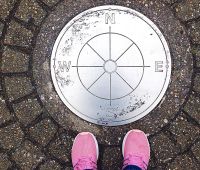 person standing next to compass-NEW CROP