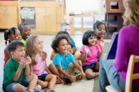 Pre-K students sitting on the floor listening to their teacher