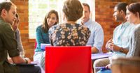 A group of teachers sitting, participating in a group discussion