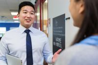 Principal speaking with teacher in school hallway