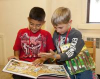 Two elementary school students reading books together