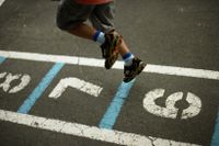 Elementary school student playing hopscotch