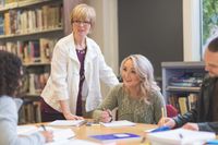 Principal and teachers talking in a library