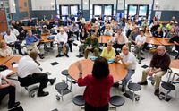 Administrator meeting with staff in a cafeteria