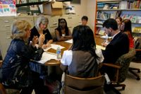 A group of teachers sitting, participating in a group discussion