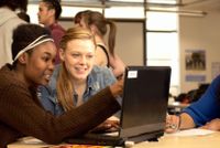 Two students working on a laptop together