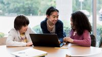 Middle school students working on a writing assignment with a laptop