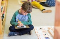 Elementary student sitting on the floor and working independently