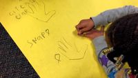 Elementary student working on an drawing-based coding project on the floor