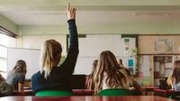 High school student raises hand in class.