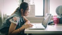 High school student working on her laptop at home
