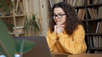 Student watching a video on her laptop at home