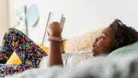 Girl reading a book in her bedroom
