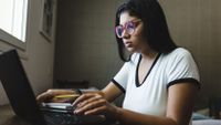 Teenage girl working on her laptop in her room