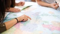 High school students point to a large map