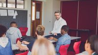 Teacher talks to high school students in the classroom.