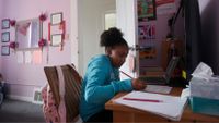 Middle school-aged girl working at home during distance learning