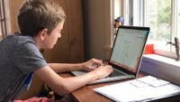 Boy doing homework on his laptop