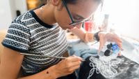 Teenage girl painting fabric