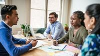 Group of adults sitting at table and having a meeting