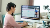 Woman participates in a meeting via video chat on her computer at home