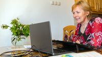 Woman using her laptop at her kitchen table