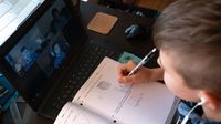 在远程学习期间，通过视频聊天完成数学课程的男孩