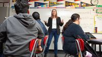 Teacher standing in front of her classroom instructing students