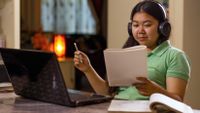 Teenage girl completing school work on her laptop