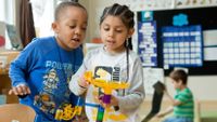 Two kindergartners working on a marble project in class