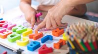 Preschooler plays with letter shapes