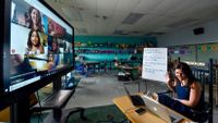 In an empty classroom, Katherine Hendrix, a third-grade teacher at J.A. Rogers Elementary, instructs students virtually, using a large screen.