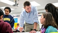 Elementary school teacher in classroom explaining math to students