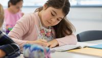 Middle school student writes in her notebook