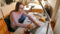 Middle school girl on laptop at home remote learning