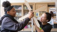 Two high school students work on science project designing wind turbine