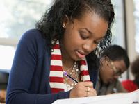A closeup of a female high school student sitting at a desk taking a test.