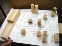 photo of a city plan created by students on paper with wooden blocks