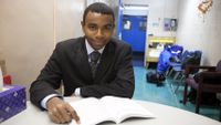 Boy in suit studying at a table